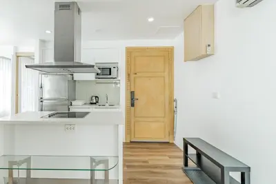a kitchen with white counters and a wooden door at Comfort SeaView Apartment with Private Plunge Pool in Patong Beach