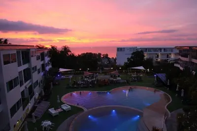 a view of a pool with a sunset in the background at The nice condo 2 BR at Karon in Karon Beach