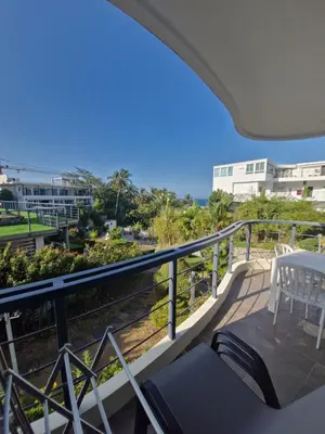 a balcony with a table and chairs and the ocean at The nice condo 2 BR at Karon in Karon Beach