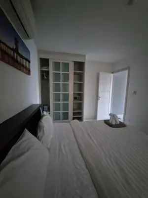 a bedroom with a large white bed with a hat on it at The nice condo 2 BR at Karon in Karon Beach