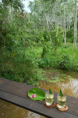 a table with two glasses and a plate on it at Kalm Cabin Phuket in Ban Phak Chit