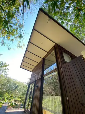 a house with a wooden door and windows at Kalm Cabin Phuket in Ban Phak Chit