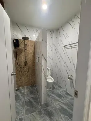 a bathroom with a shower and a toilet at Falisa House Apartment Bangtao in Ban Thalat Choeng Thale
