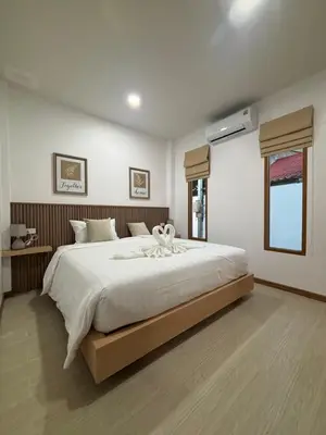 a bedroom with a large white bed in a room at Falisa House Apartment Bangtao in Ban Thalat Choeng Thale
