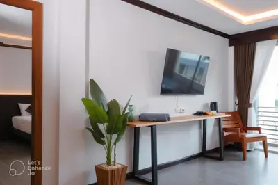 a room with a desk and a tv on a wall at Oh'tel Kata in Kata Beach