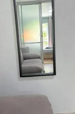 a mirror on a wall with a chair in a room at D Condo Kathu Monthly Stay Near Patong 30 Day Minimum in Kathu