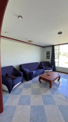 a living room with blue couches and a coffee table at Liina House in Ko Yao Noi