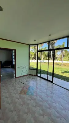an empty room with a room with windows and a chair at Liina House in Ko Yao Noi