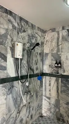 a bathroom with a shower with a shower head at Liina House in Ko Yao Noi