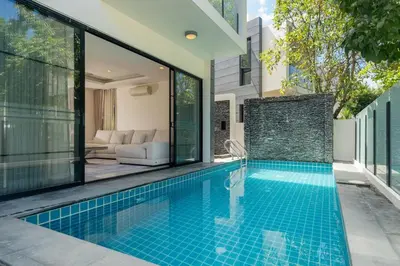 a swimming pool in a villa with glass walls at Friendly Lux 5 Bedroom Villa Laguna park in Laguna Phuket
