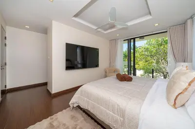 a bedroom with a large bed with a ceiling fan at Luxury 5 bed Laguna Park no Pool in Laguna Phuket