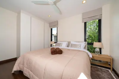 a white bedroom with a large bed with a ceiling fan at Luxury 5 bed Laguna Park no Pool in Laguna Phuket