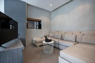 a living room with a couch and a flat screen tv at 2 BR Pool View in Wellness Residence near Beach P503-4 in Kamala Beach