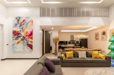 a living room with a couch and a painting on the wall at Prestige 4BR Private Pool Residence in Rawai in Ban Kata