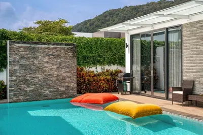 a swimming pool with pillows on the side of a house at Prestige 4BR Private Pool Residence in Rawai in Ban Kata
