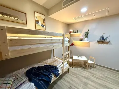 a bedroom with two bunk beds and a table at Family apartment 2-BR with Sea View - Karon Beach in Ban Karon