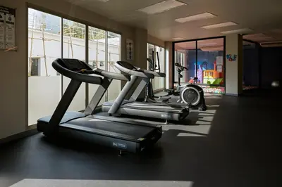 a gym with three cardio machines in a room at Family apartment 2-BR with Sea View - Karon Beach in Ban Karon