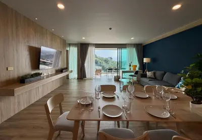 a dining room with a table and a living room at Family apartment 2-BR with Sea View - Karon Beach in Ban Karon