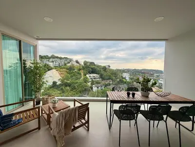 a dining room with a table and a large window at Family apartment 2-BR with Sea View - Karon Beach in Ban Karon