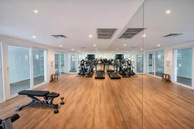 an empty gym with several treadmills and exercise bikes at Santosa Hotel & Welness Center in Ban Kata