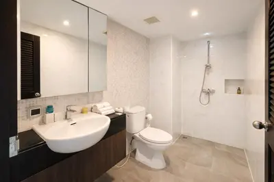 a bathroom with a sink and a toilet and a shower at Santosa Hotel & Welness Center in Ban Kata