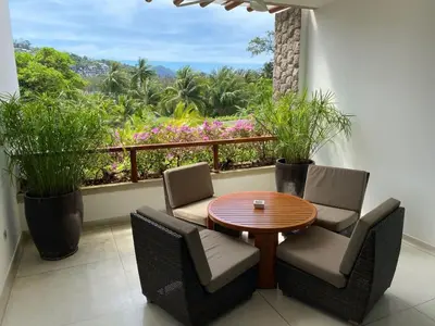 a balcony with a table and chairs and a window at Beachfront 2 BR Luxury Condominium Surin in Surin Beach