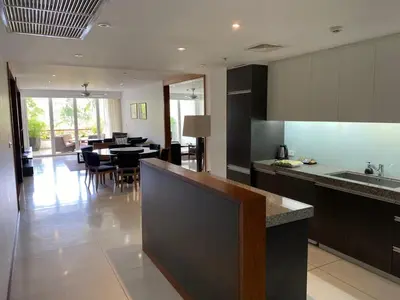 a kitchen with a counter and a dining room at Beachfront 2 BR Luxury Condominium Surin in Surin Beach