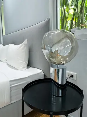 a table with a glass globe on top of it next to a bed at The Pelican Residence & Suites Krabi in Ban Ko Kwang