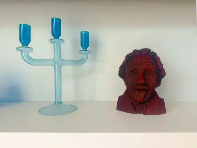 a statue of a head next to two blue candles at The Pelican Residence & Suites Krabi in Ban Ko Kwang