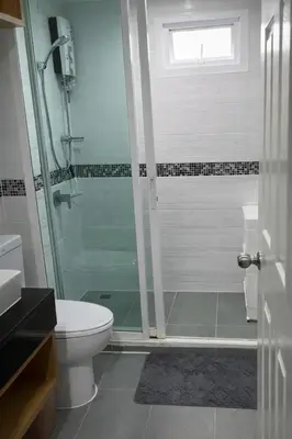 a bathroom with a toilet and a glass shower at The View Condo Monthly Stay Near Central Phuket 30 Day Minimum in Ban Rangeng