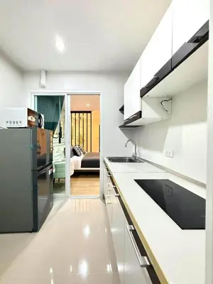 a kitchen with white cabinets and a black refrigerator at The View Condo Monthly Stay Near Central Phuket 30 Day Minimum in Ban Rangeng