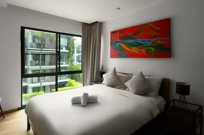 a bedroom with a white bed and a large window at The Title Condo 2BR by G Estate Phuket in Phuket Town