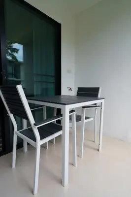 a white table with two chairs and a laptop on it at The Title Condo 2BR by G Estate Phuket in Phuket Town