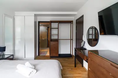 a bedroom with a bed and a dresser with a mirror at The Title Condo 2BR by G Estate Phuket in Phuket Town