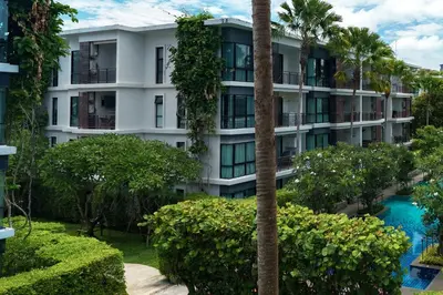 an apartment building with a swimming pool and palm trees at The Title Condo 2BR by G Estate Phuket in Phuket Town