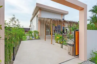 a walkway outside of a house with plants at Tom Star Pool Villa Layan in Thalang