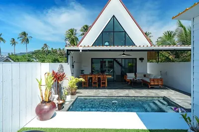 a villa with a swimming pool and a house at Lili Villa by G Estate Phuket in Nai Harn Beach