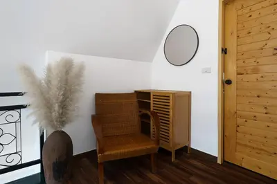 a room with a chair and a mirror on a wall at Lili Villa by G Estate Phuket in Nai Harn Beach