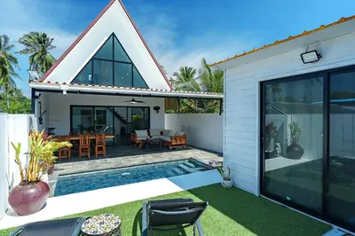 a villa with a swimming pool and a house at Lili Villa by G Estate Phuket in Nai Harn Beach