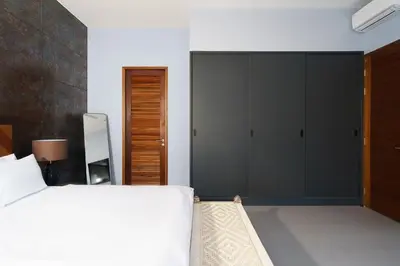 a bedroom with a bed and a large closet at Ramon Villa by G Estate Phuket in Ban Saiyuan (1)