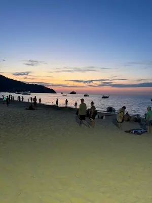 a group of people on the beach at sunset at 1 BDR 5 Swimming Pool Entire Condo 5 Mins Walk To Naiyang Beach in Nai Yang Beach