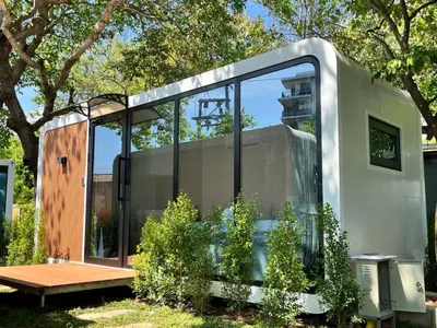 a modern house with glass doors and a bench at NeOtel Apartments in Ban Saiyuan (1)