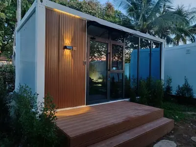 a small house with a wooden porch and glass doors at NeOtel Apartments in Ban Saiyuan (1)