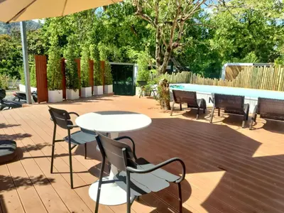 a patio with a table and chairs and a pool at NeOtel Apartments in Ban Saiyuan (1)