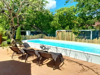 a swimming pool with chairs next to a fence at NeOtel Apartments in Ban Saiyuan (1)