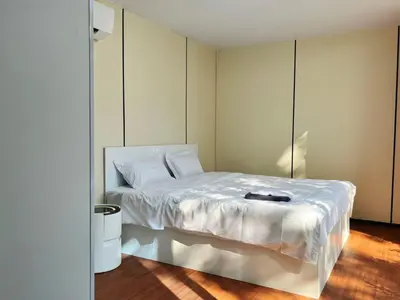 a bedroom with a white bed with a book on it at NeOtel Apartments in Ban Saiyuan (1)
