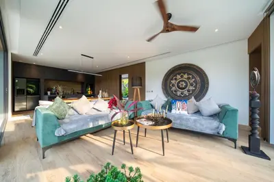 a living room with two blue couches and a table at Cocoon Villa 6 - Eden Escape 3 BR - Pool - Garden in Ban Sakhu