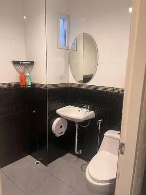 a bathroom with a sink and a toilet and a mirror at Cozy 2-Bedroom Place in a Quiet Area Nearby Beach in Ban Lum Fuang