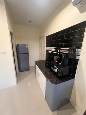 a kitchen with a black counter top and a refrigerator at Cozy 2-Bedroom Place in a Quiet Area Nearby Beach in Ban Lum Fuang