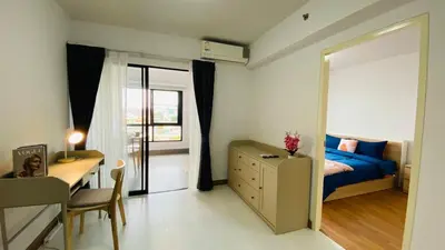 a bedroom with a bed and a desk and a mirror at Vista Residence Old Town in Phuket Town